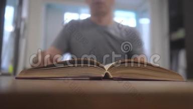 男人正在看一本书慢镜头。教育学习图书馆理念。男人打开书。男人翻页